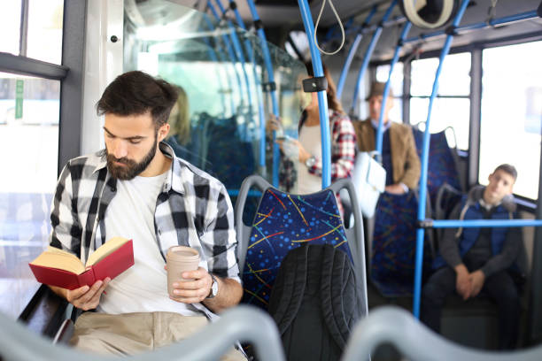istock Young man reading a book in bus 1144087868