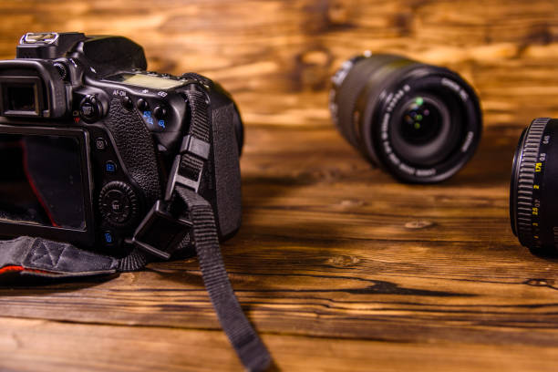 istock Modern dslr camera and lenses on wooden table 1144089128