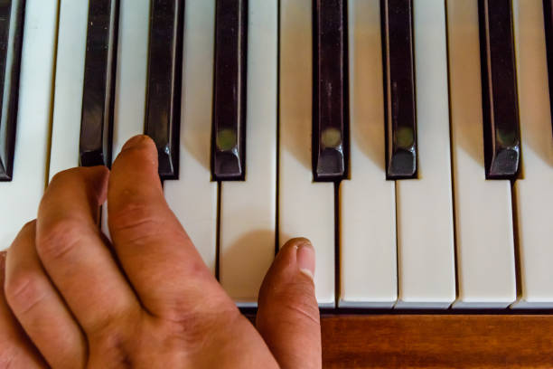 istock Child hand on the shiny piano keys. Top view 1144089145