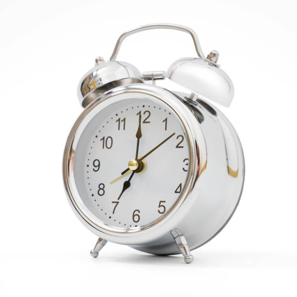 istock Silver retro alarm clock on isolated background 1144103517