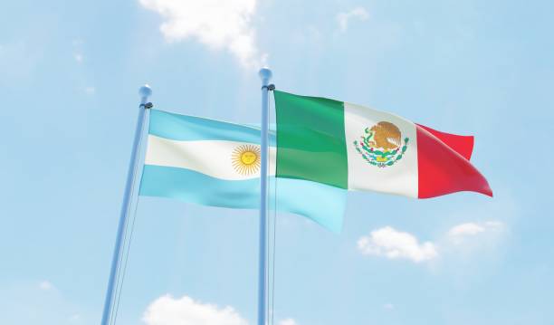 istock Argentina and Mexico, two flags waving against blue sky 1144108196