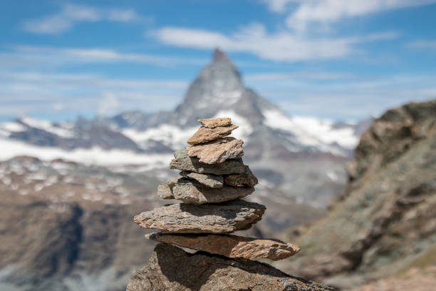View balance stones, far away Matterhorn mountain, scene in national park Zermatt, Switzerland, Europe. Summer landscape, sunshine weather, dramatic blue sky and sunny day