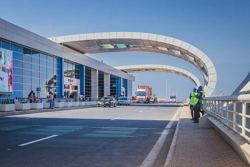 DAKAR, SENEGAL, FEBRUARY 22 2018: Departure platform on the new Blaise Diagne airport in Dakar, Senegal on a sunny day. Some people, security guards and cars are seen parked.