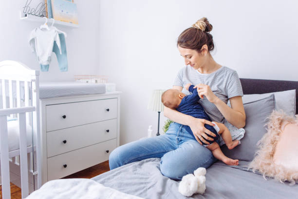 Breastfeeding mother Mother breastfeeding baby son in bedroom, they enjoy in this moment together 2 5 months photos stock pictures, royalty-free photos & images