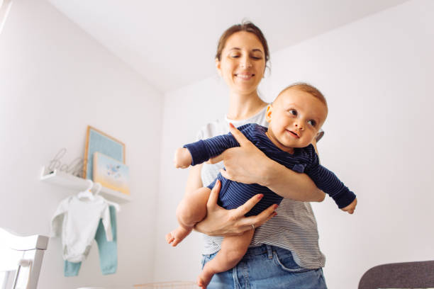Playing with baby Mother carrying baby son in bedroom, they playing flying airplane 2 5 months stock pictures, royalty-free photos & images
