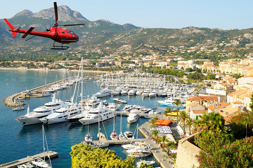 Helicopter flying over Calvi harbor, Corsica, Europe.