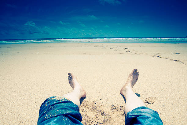 Vacation, mans feet on a beautiful sunny beach