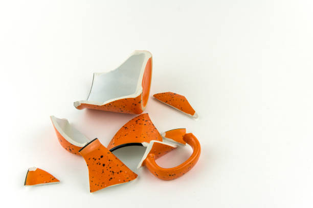 istock Broken orange mug on white background. Numerous pieces of the Cup. 1144130659