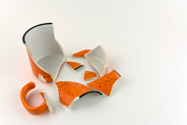 istock Broken orange mug on white background. Numerous pieces of the Cup 1144130725