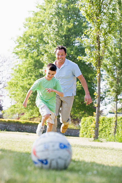 istock Father and son outdoors playing soccer 114413309