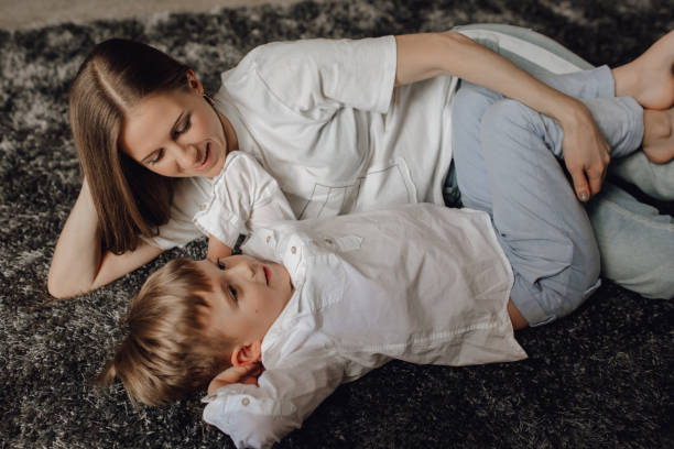 istock Beautiful Woman Son Smiling while Lying on Floor 1144133874