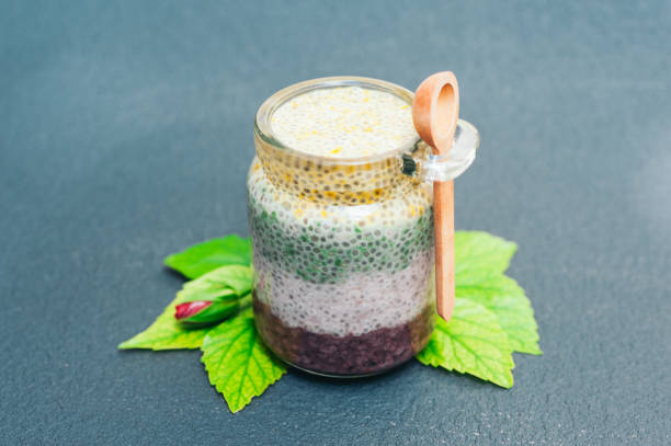 Healthy dessert and proper nutrition concept. Chia pudding in glass jar with wooden spoon. Chia seeds. Superfood. Selective focus. Milk dessert