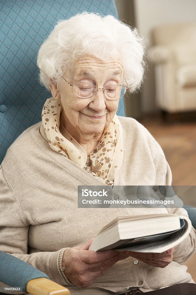 Senior Woman Relaxing In Chair Reading Book  80-89 Years Stock Photo