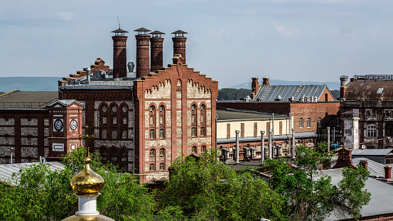 Old brick building on a background of green trees and sky in Samara. Russia