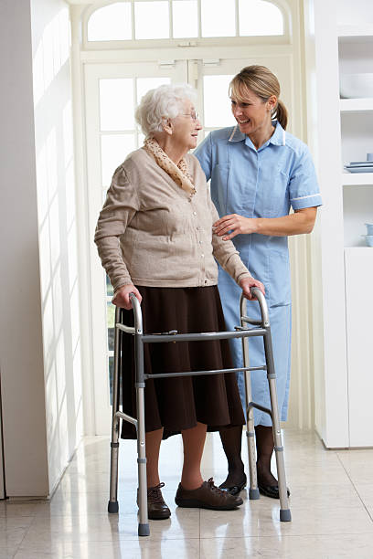 istock Carer Helping Senior Woman Using Walking Frame 114413499