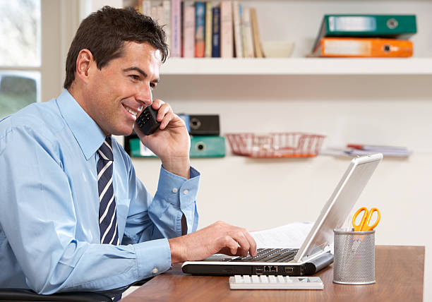 istock Businessman working from home using laptop and phone  114413513
