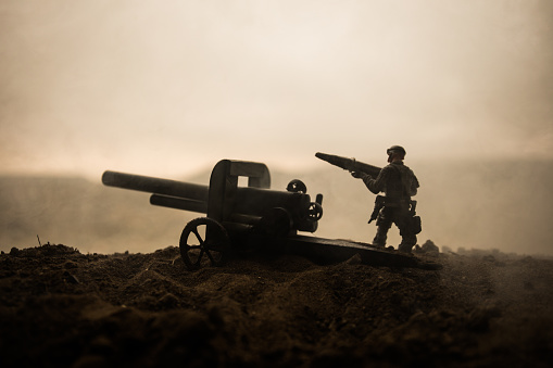Battle scene. Silhouette of old field gun standing at field ready to fire. Creative artwork decoration. Selective focus