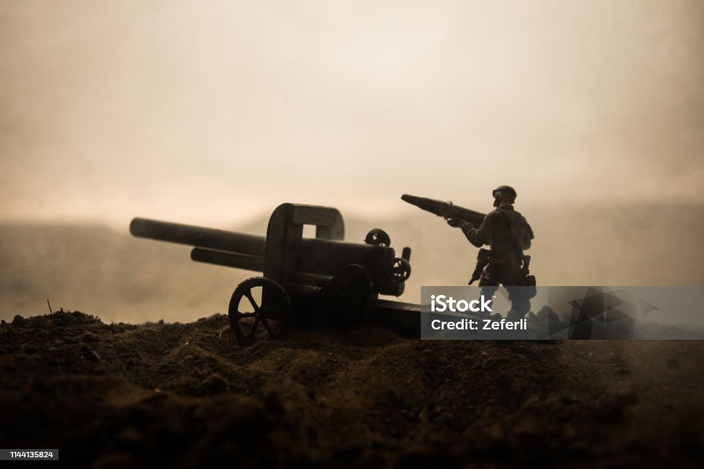 Battle scene. Silhouette of old field gun standing at field ready to fire. With colorful dark foggy background. Selective focus Battle scene. Silhouette of old field gun standing at field ready to fire. Creative artwork decoration. Selective focus Army Stock Photo