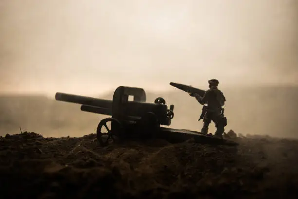 Battle scene. Silhouette of old field gun standing at field ready to fire. Creative artwork decoration. Selective focus