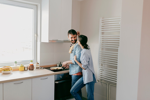 Portrait of Happy Young Couple Cooking Together in the Kitchen at Home. Romantic Young Couple Cooking Together in the Kitchen,having a Great Time Together.
