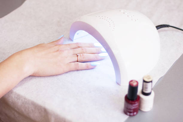 Woman using UV light dryer. Manicure, spa salon concept. Beauty and fashion. - fotografia de stock