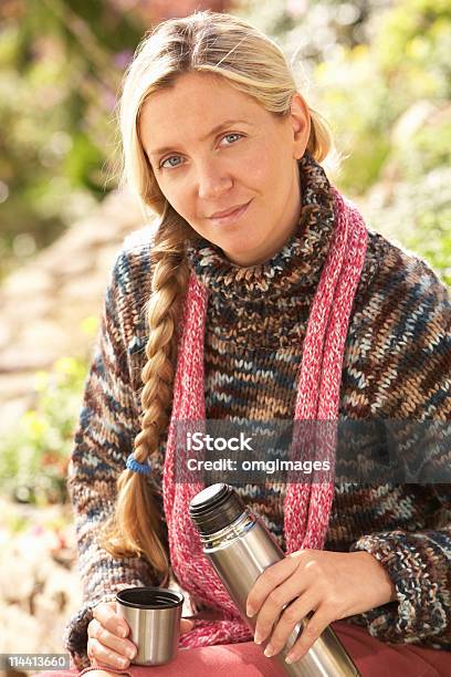 Woman Relaxing With Thermos Flask In Countryside Stock Photo - Download Image Now - 20-29 Years, Adult, Adults Only