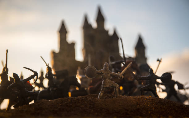 istock Medieval battle scene with cavalry and infantry. Silhouettes of figures as separate objects, fight between warriors on sunset foggy background. 1144137913