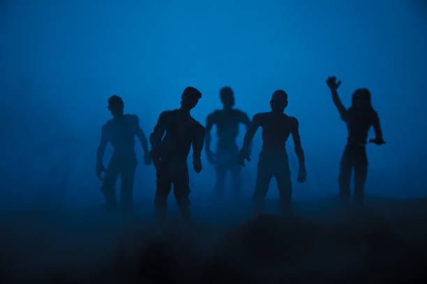 istock Silhouette some zombies on the cemetery walking around at sunset. Selective focus 1144137947