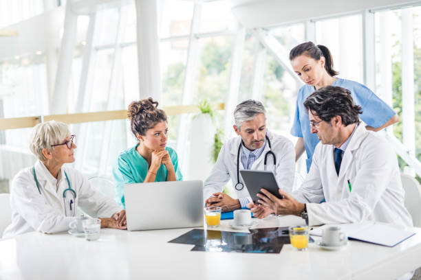 istock Group of medical experts working on wireless technology at doctor's office. 1144138169