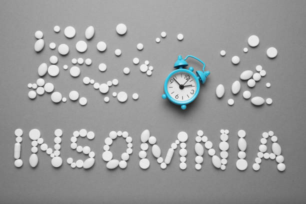 istock Sleeping pills and an alarm clock, insomnia concept. Stress and sleep problems 1144139589