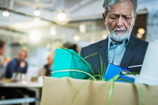 retired senior businessman leaving the office with his belongings. - firing unemployment downsizing box imagens e fotografias de stock