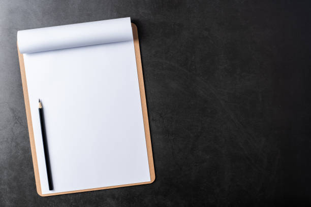 istock white paper with clipboard on black stone background 1144144363