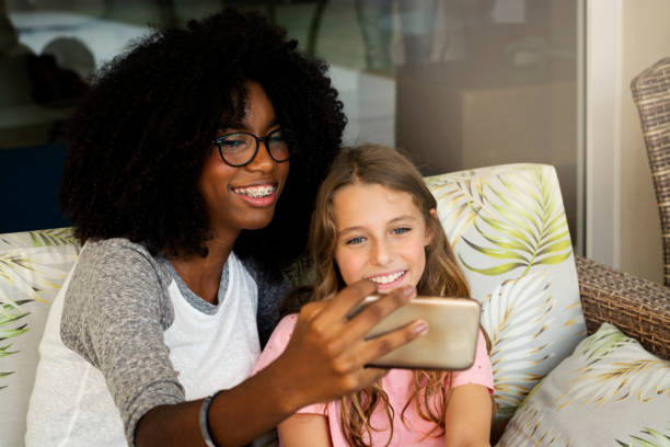 istock Two girls, looking at cell phone and smiling 1144148015