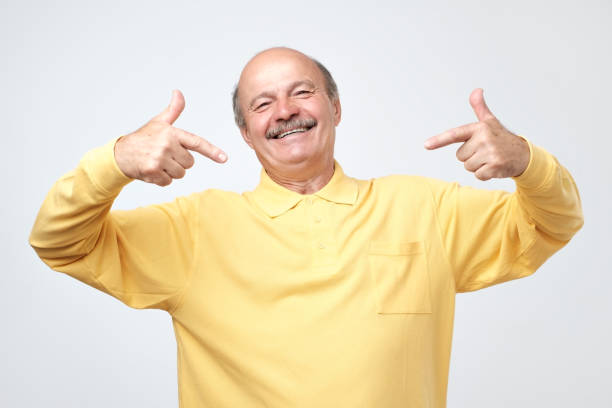 istock Bald man looking confident with smile on face, pointing himself with fingers 1144149196