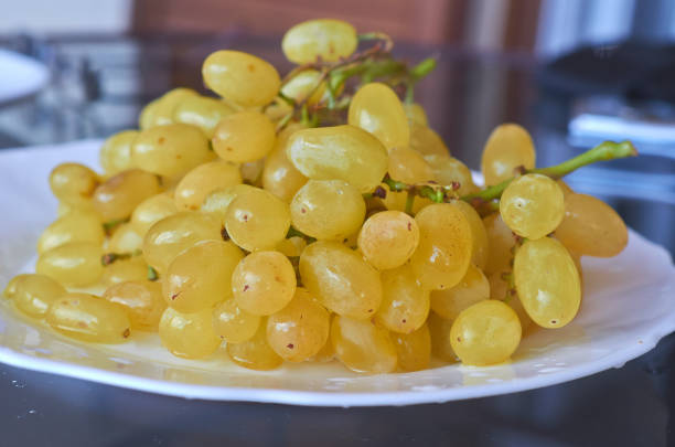 istock Bunch of white grapes on a plate, close up. 1144150245