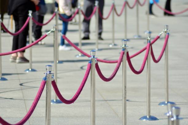 istock Silver stanchions with a purple rope 1144152036