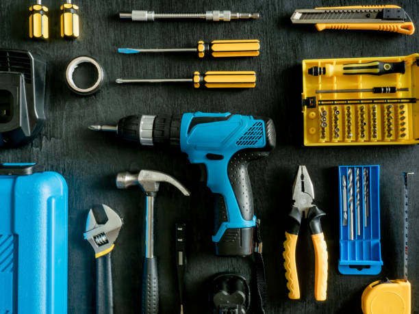 vista superior del concepto de herramientas de construcción con conjuntos de taladro, martillo, destornillador y caja de herramientas sobre fondo de madera negro. - tool belt belt work tool pliers fotografías e imágenes de stock