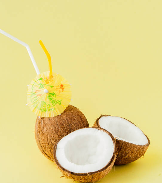 istock Fresh Coconut cocktail with a straws on yellow background, copy space 1144153303