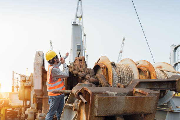 istock Foreman using walkie-talkie and safety helmet to work in cargo ship 1144153626