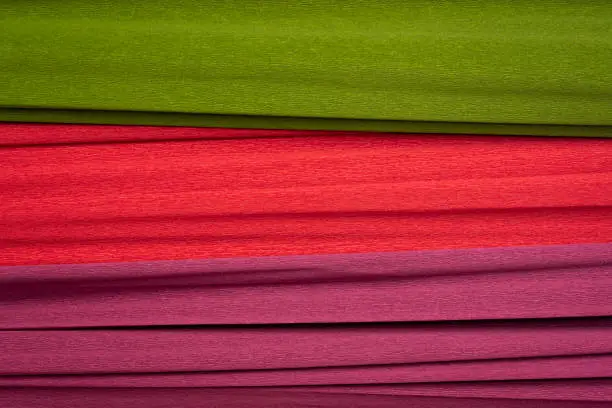 red, green and purple crepe paper - background with crinkled texture