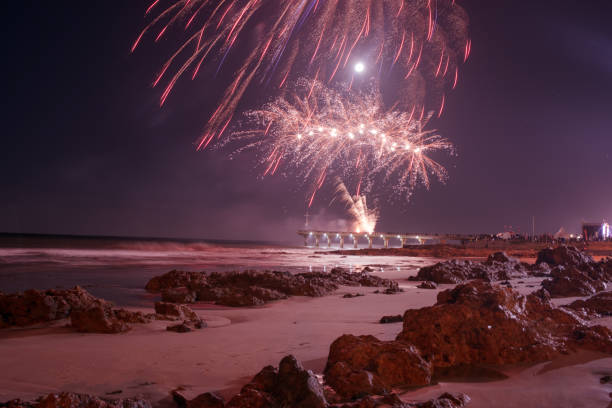 istock Fireworks going off on pier and lighting the sky brightly 1144157938
