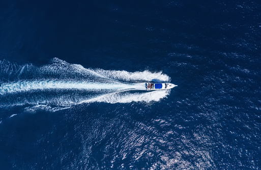 Yachts at the sea in Bali, Indonesia. Aerial view of luxury floating boat on transparent turquoise water at sunny day. Summer seascape from air. Top view from drone. Seascape with motorboat in bay. Travel - image