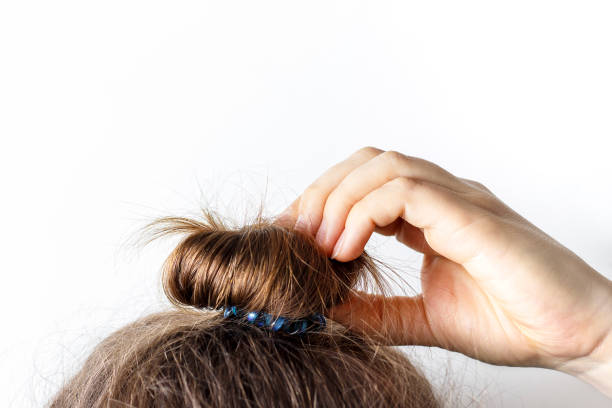 istock Female hand correct the bun on white background. Modern fast hairstyle. 1144159696