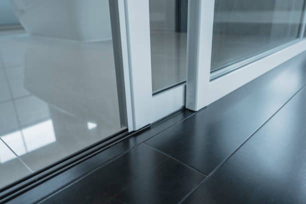 detail of sliding door frame install with floor laminate and floor tile joint together stock photo