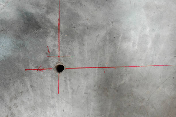 istock A hole is drilled in the concrete wall using the markings. 1144160898
