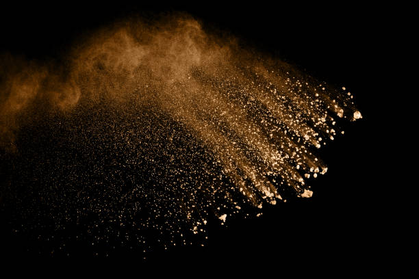 istock Brown particles splattered on black background. Brown dust splashing. 1144163240