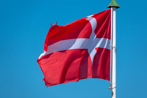 istock a flag of Denmark blowing before a blue sky 1144166069