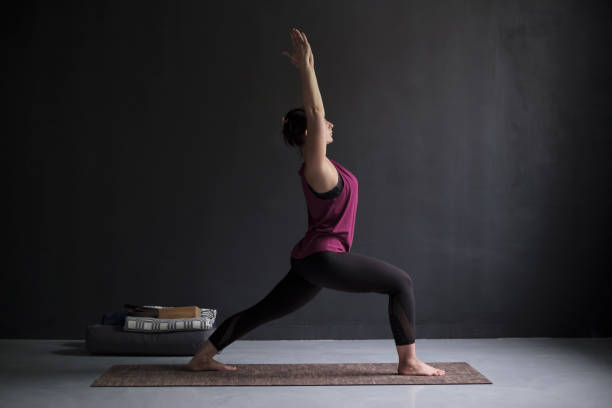 istock Young woman practicing yoga, doing Virabhadrasana 1 exercise 1144168767