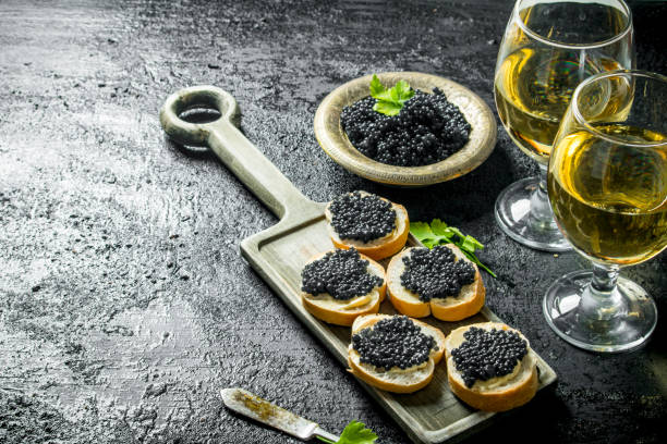 istock Sandwiches with black caviar and the wine. 1144171964