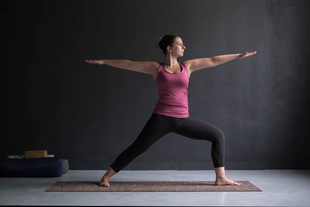 istock Woman practicing yoga, standing in Warrior Two exercise, Virabhadrasana II pose 1144172730